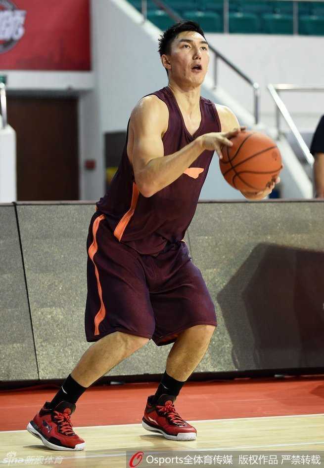 孙桐林在篮下进行对抗后的勾手投篮，肌肉线条在灯光下清晰可见，神情专注，对待训练如同实战。