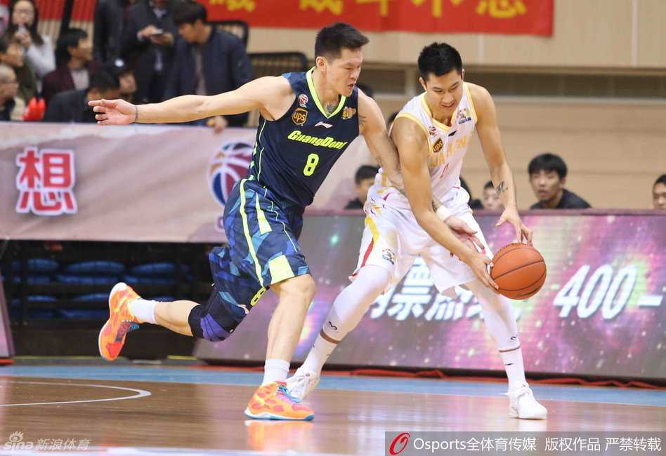 暂停时段，球员们在场边歇息，杜锋指导拿着战术板蹲在地上，神情专注地向队员们布置战术。