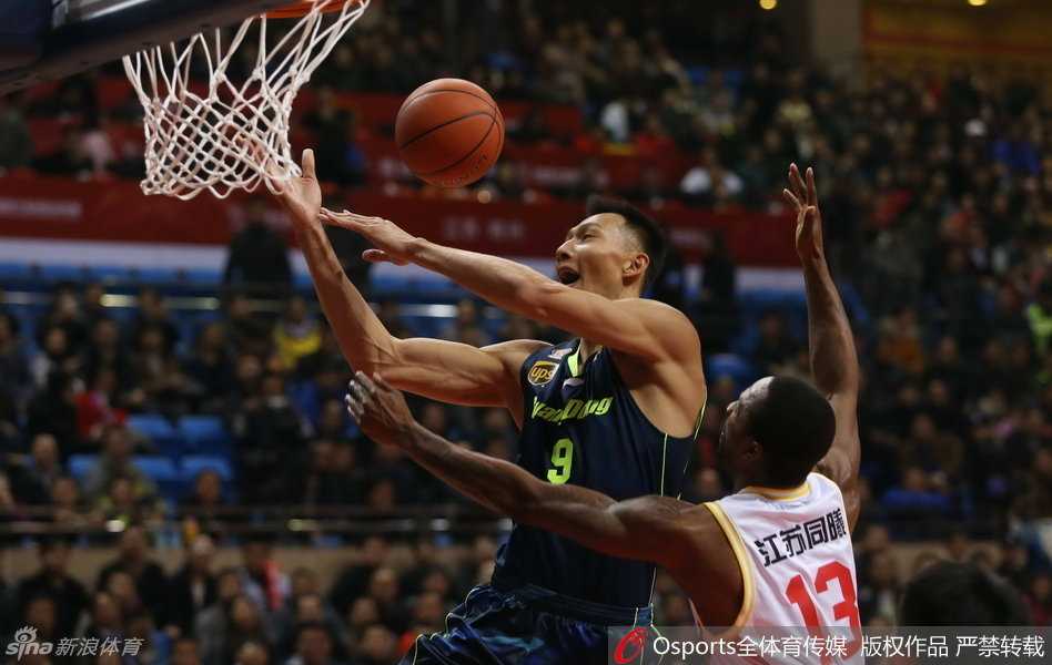 朱芳雨持球强行切入，他顶开防守者，眼神坚毅地注视着篮筐，展现出老将的勇猛。