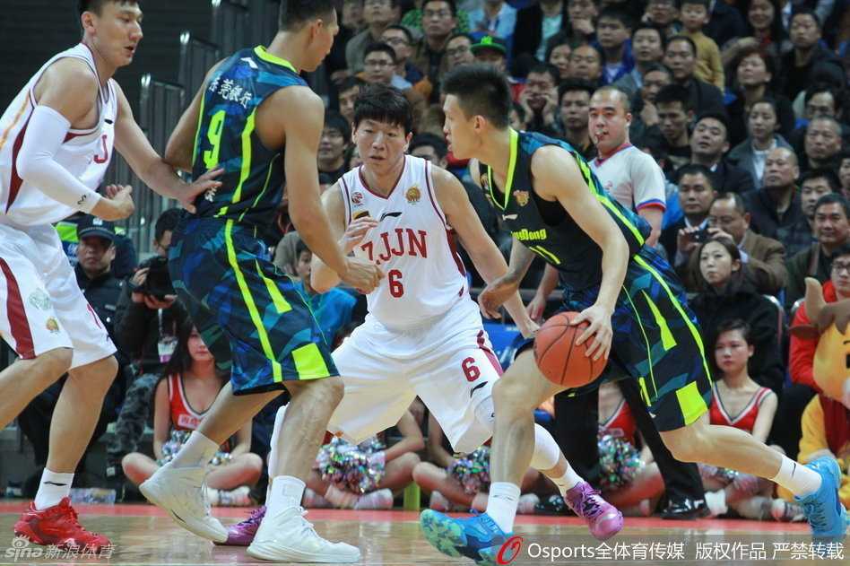 易建联在三人合围中强硬转身，面对高高跃起的防守者，毅然选择起身投篮，肌肉线条迸发出力量美感。