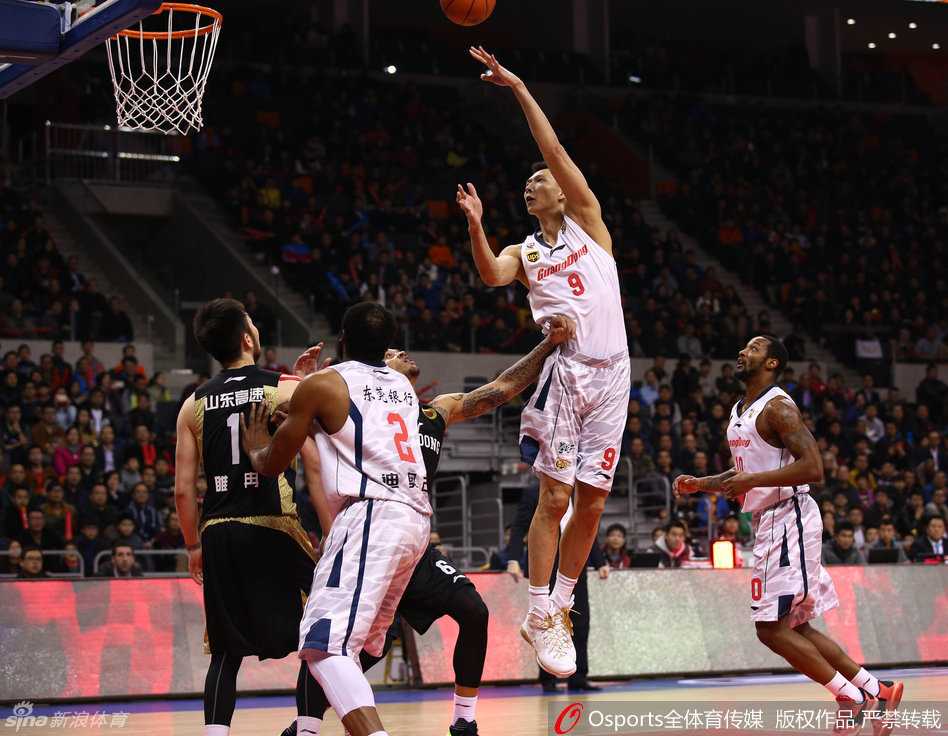 易建联在广东与山东的季后赛中，面对防守球员轻盈挑起，采用抛投完成进攻，眼神专注而坚定。
