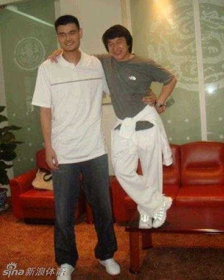 邓超孙俪夫妇恩爱合体，邓超黑色礼服搞怪比心，孙俪露肩白裙优雅甜美，两人在座位上相视而笑。