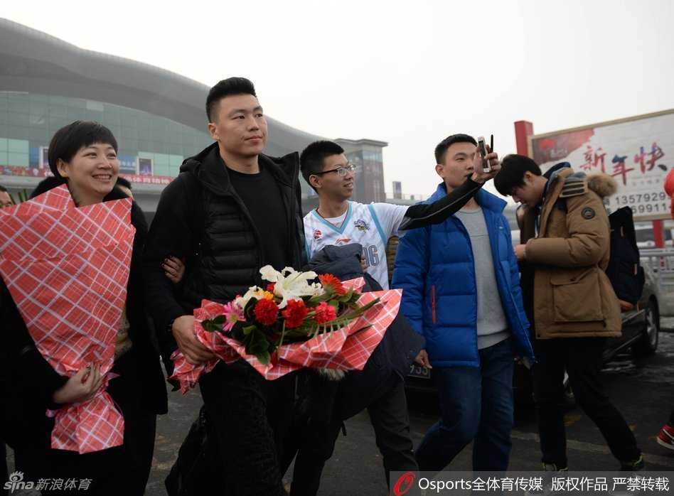 一位女球迷兴奋地展示着刚刚获得的刘炜签名，眼睛笑成了月牙，身旁的同伴投来羡慕的目光。