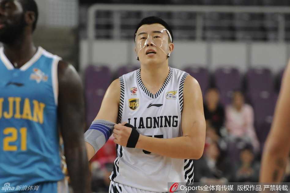 王哲林高高跃起，伸出长臂迎面封盖韩德君的投篮，两人在空中形成激烈的身体对抗。