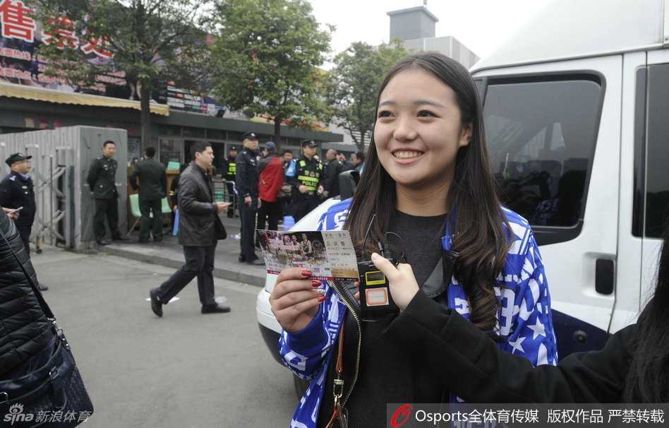 一位女球迷在深夜的排队人群中，终于将这张来之不易的总决赛门票紧紧握在手中，脸上绽放出如获至宝般的灿烂笑容，眼中闪烁着期待与激动。