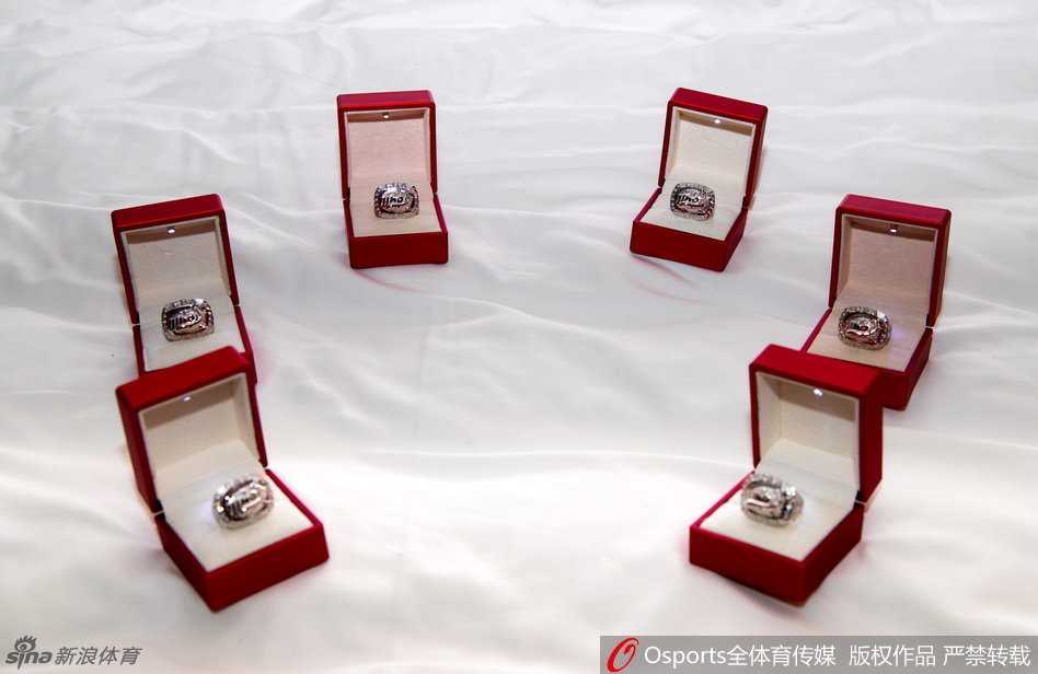 四川省体育馆内灯光璀璨，四川男篮全体队员高举紧握的右拳，将刚刚戴上的总冠军戒指面向观众，脸上洋溢着骄傲与幸福的笑容