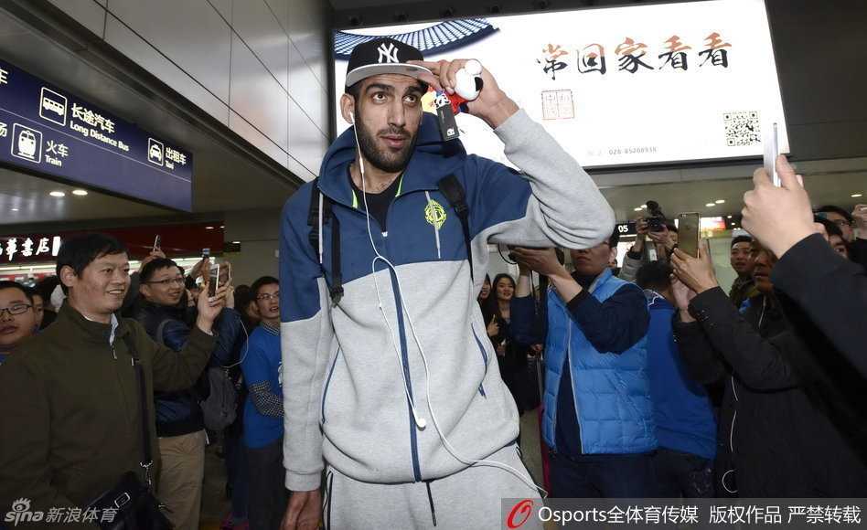 伊朗中锋哈达迪面带轻松的微笑走出机场到达口，他身着休闲运动装，一手推行李，一手拿着手机，仿佛也被成都球迷的热情所感染。