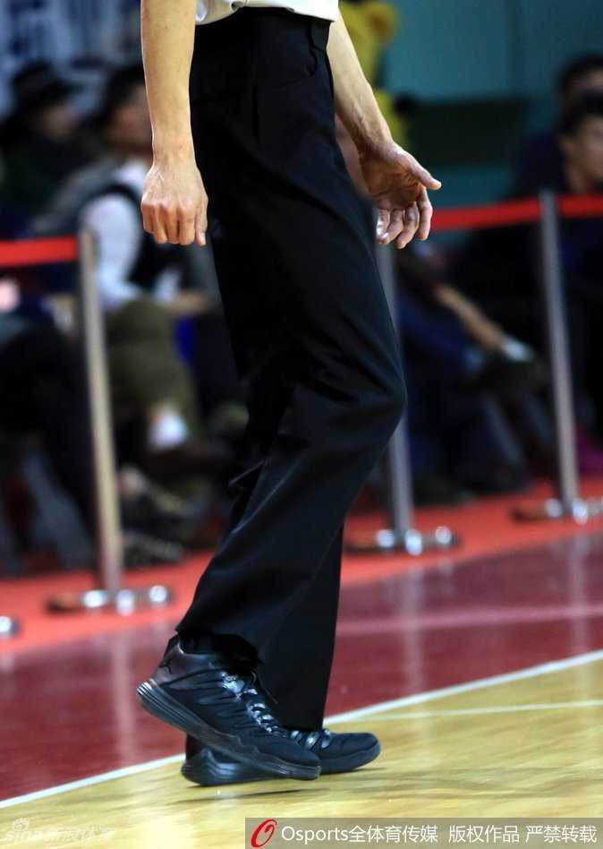 裁判抬起脚展示球鞋侧面，经典的飞人logo未经任何贴标处理，鞋底纹路还沾染着球馆地板的痕迹