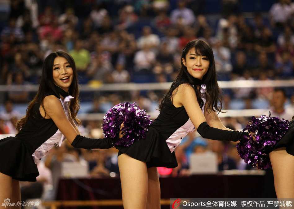 近景镜头中，一位篮球宝贝在表演间隙回眸一笑，甜美的气质与动感的赛场背景形成奇妙对比，展现出力与美的和谐交融。