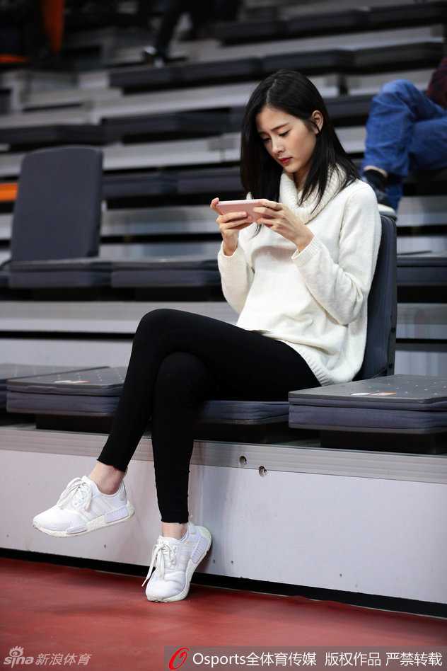 面对镜头的捕捉，这位女球迷莞尔一笑，随意披散的长发和若隐若现的锁骨，展现出东方女性特有的柔美与性感。