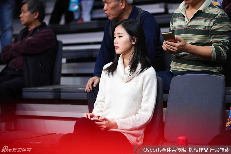 目光锁定赛场，这位白衣女球迷在广东队一次成功的防守后，露出了浅浅的梨涡，那份专注与美丽让人心动。