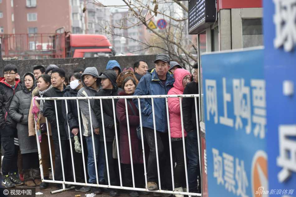 透过攒动的人群缝隙，可见维持秩序的安保人员严阵以待，而球迷们则垫脚张望，焦急又兴奋地注视着售票窗口的方向，生怕错过前进的每一步。