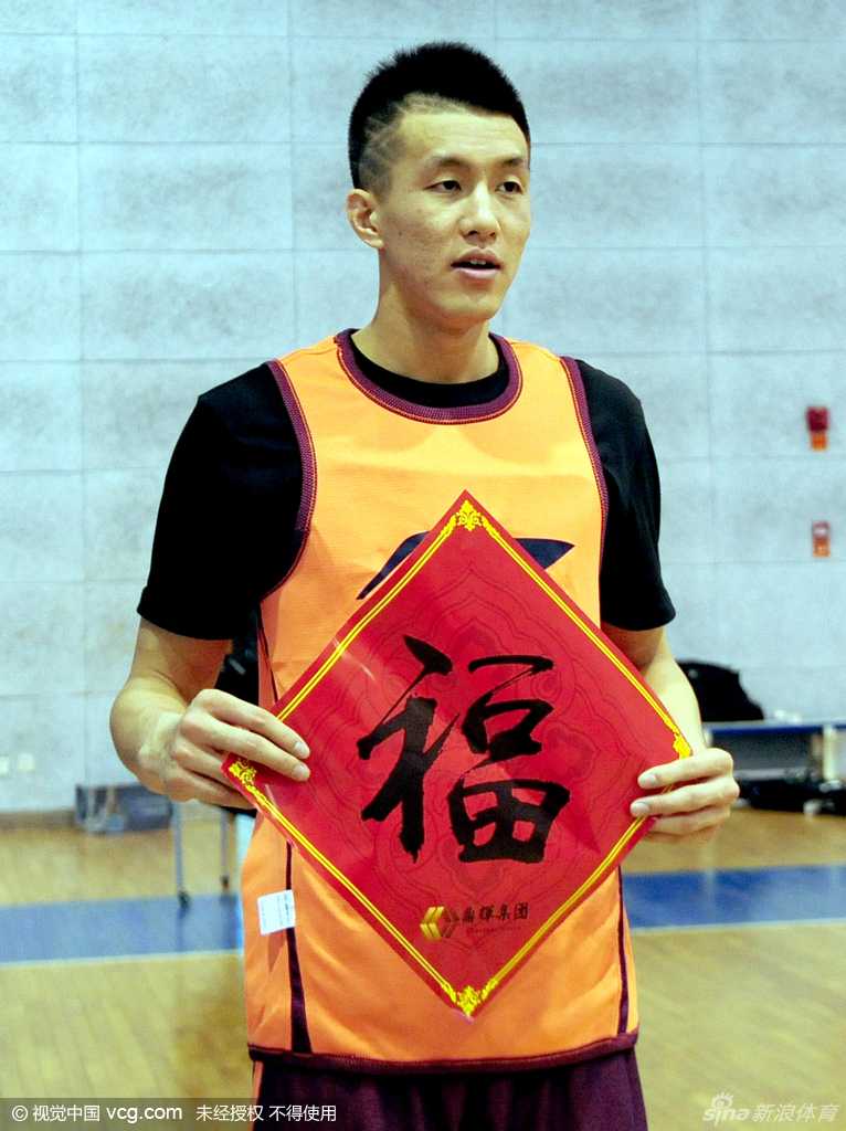 内线双塔韩德君和李晓旭并肩而立，共同举着一个大大的福字，大韩笑容憨态可掬，李晓旭则露出少有的轻松微笑，身后背景是训练馆的篮筐。