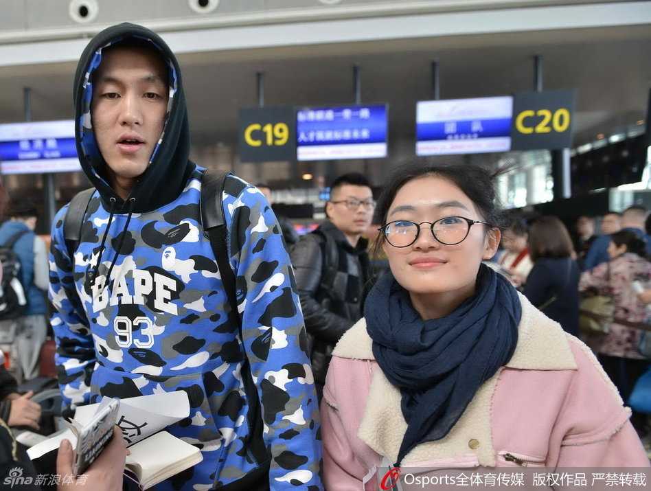 韩德君庞大的身躯背着双肩包，手里紧紧攥着那张通往客场城市的登机牌，像一座移动的铁塔守护着队伍。