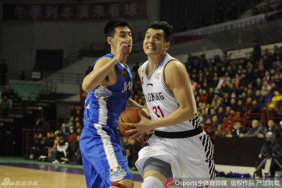 曹飞面对赵继伟的紧逼防守，压低重心运球，眼神余光扫视着场上队友的跑位，力求稳稳掌控比赛节奏。