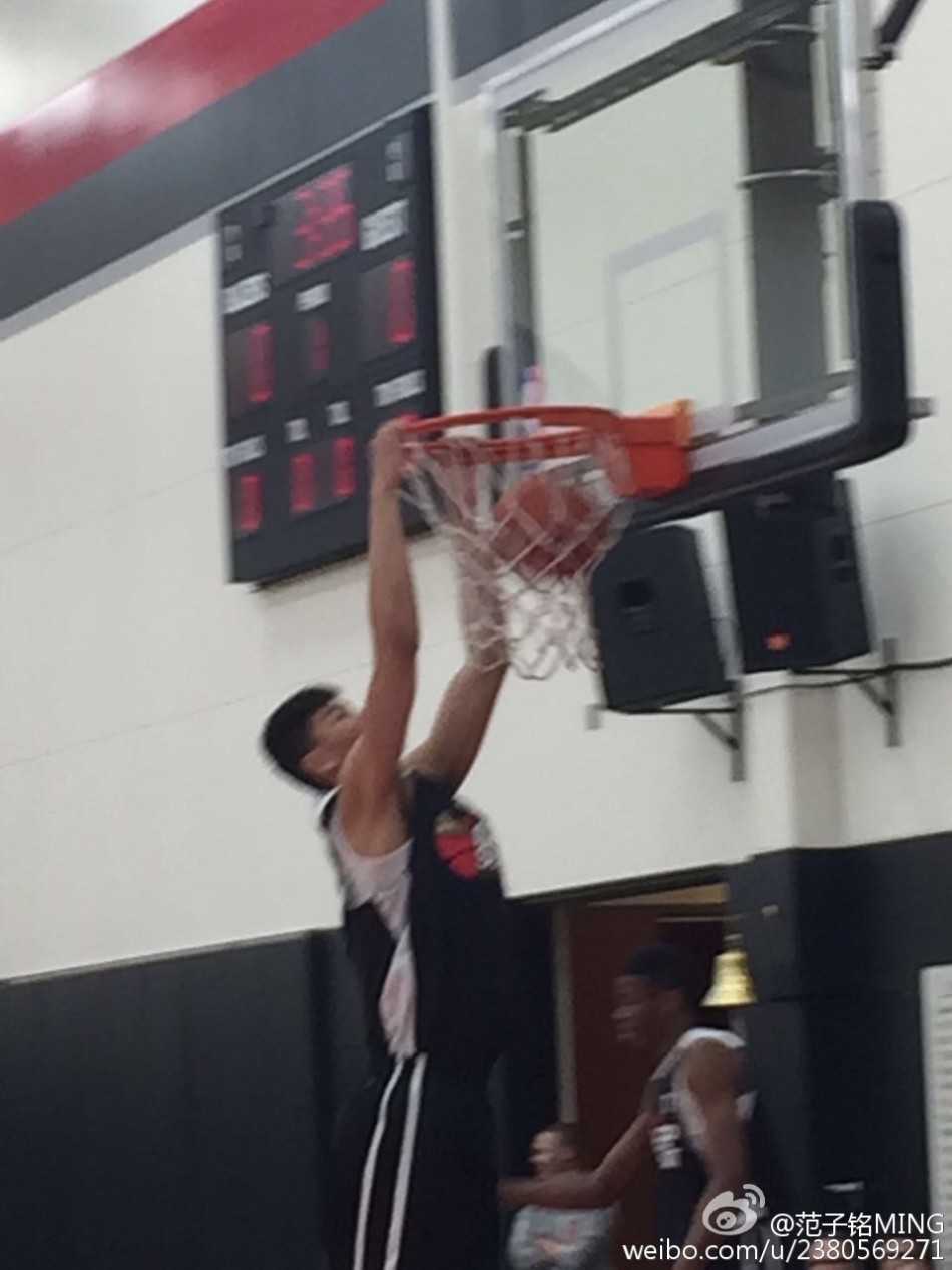 比赛结束后，范子铭与辽宁队主教练郭士强在场边亲切合影，两人面带微笑，背后是波特兰球馆的看台。