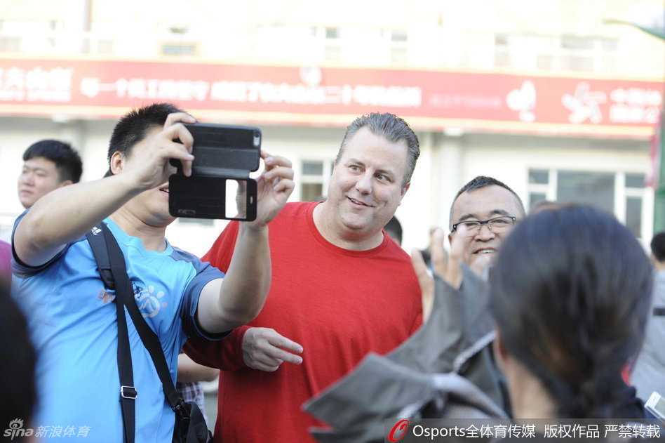 邓华德在看台上与热情的球迷们合影留念，他心情大好，现场气氛热烈，充分展现了他在长春超高的人气。
