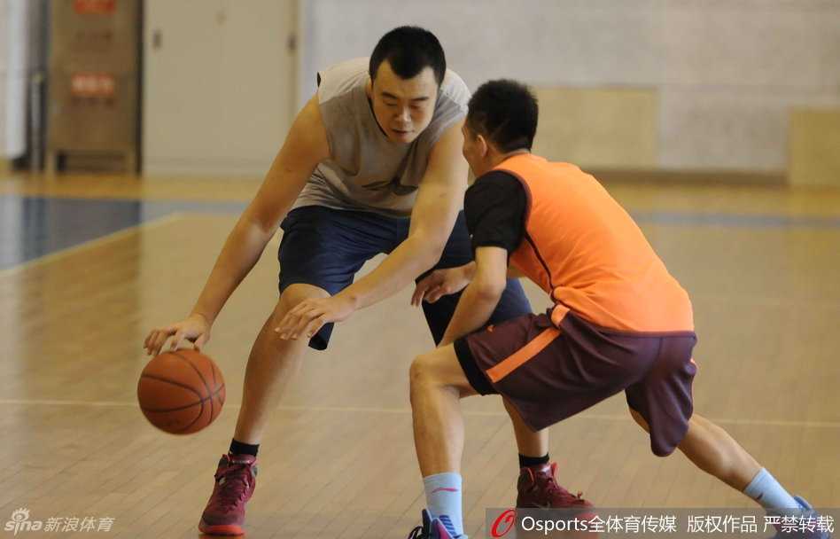 训练间歇，郭艾伦和父亲并肩坐在场边，艾伦侧身认真听父亲说着什么，父子俩神情专注而亲密。