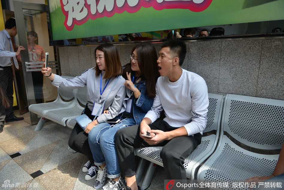 郭艾伦耐心地与场边的小球迷交流互动，弯下高大的身躯，仔细聆听小朋友说话。