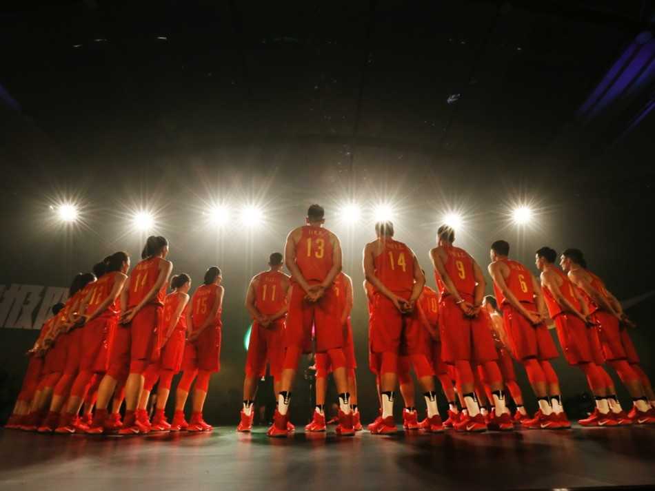 男篮核心易建联在出征仪式上神情专注地聆听主持人提问，作为全队最稳的基石，他的眼神中透露着对第三次奥运之旅的坚定与担当。