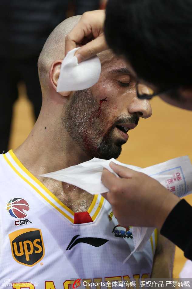 队医紧急为阿巴斯处理脸颊伤口，阿巴斯眼神坚毅，鲜血已渗透了手中的毛巾。