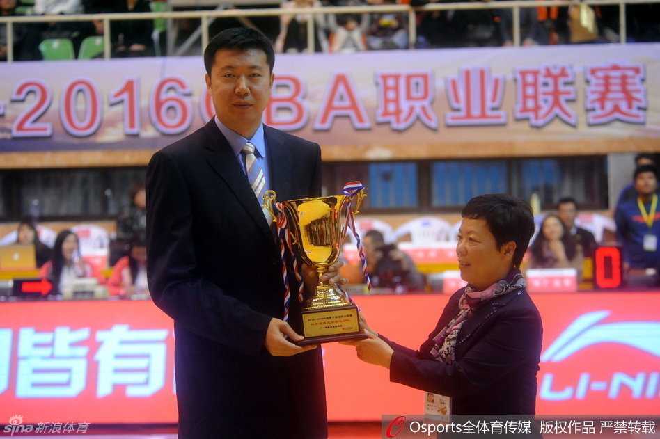 王治郅手捧精致的奖杯，与身旁身着正装的嘉宾并肩合影，他标志性的微笑如同冬日暖阳，照亮了这个属于他的特殊夜晚。