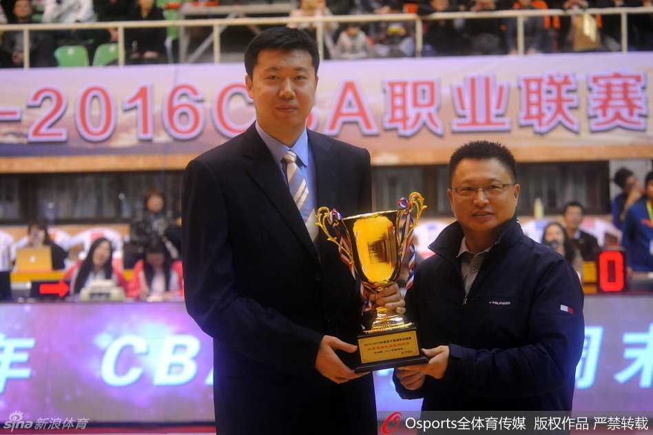 王治郅身着笔挺的正装，双手郑重地接过那座代表着无上荣誉的奖杯，眼神中透露出的是对这个赛场的无限眷恋与释然。