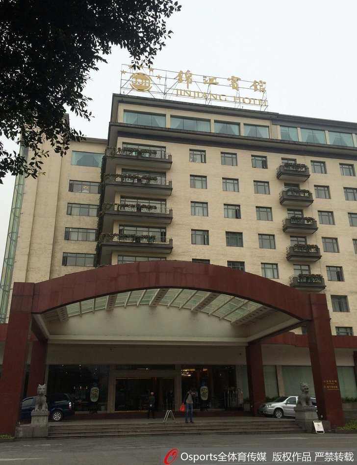 锦江宾馆标志性的玻璃幕墙前，偶尔有行人匆匆走过，但酒店大门内侧却异常空旷寂静，巨大的建筑体量在黄昏中显得冷漠而疏离，与往日接待贵宾时的热闹形成强烈反差。