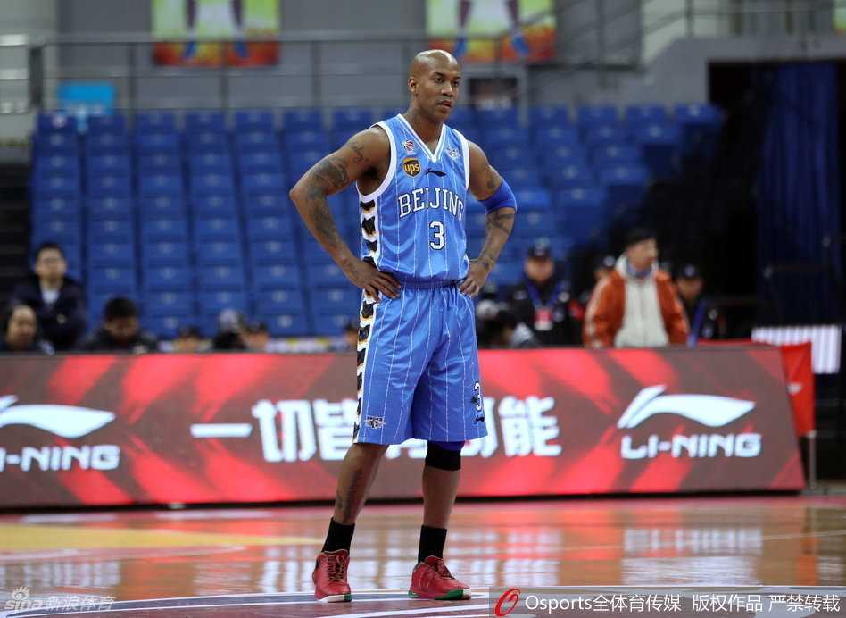 老将张庆鹏在三分线外果断出手，身体完全舒展开来，眼神紧盯着飞旋的篮球，背景是略显空旷的看台，这一球寄托着追分的希望。