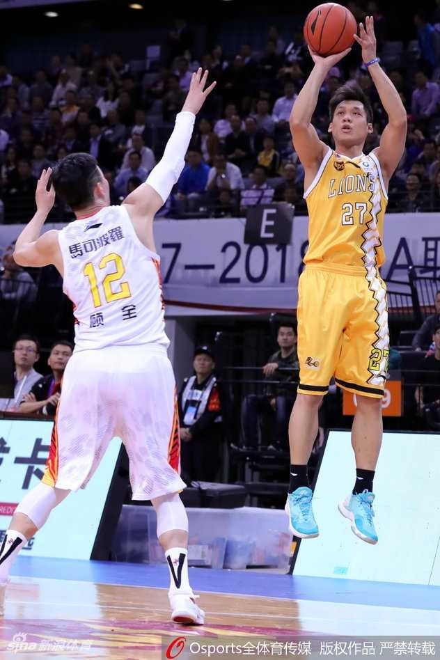 广厦队小将胡金秋在萨林杰的强力防守下，依然强硬地将球放入篮筐，两人手臂纠缠肌肉紧绷，充满了力量对抗感