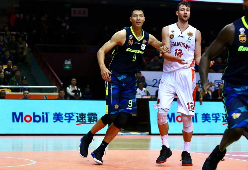 CBA第10轮:劳森末节狂飙20分,山东高速主场15分大胜广东宏远 广东核心易建联在三人合围中拼抢篮球,眼神坚毅,誓要为球队夺回领先优势