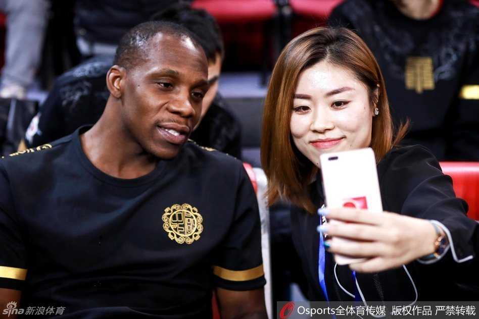 身穿时尚便装的哈德森在采访区外巧遇美女记者，面对镜头他露出了标志性的憨厚笑容，竖起大拇指大方配合合影，心情看起来相当不错。