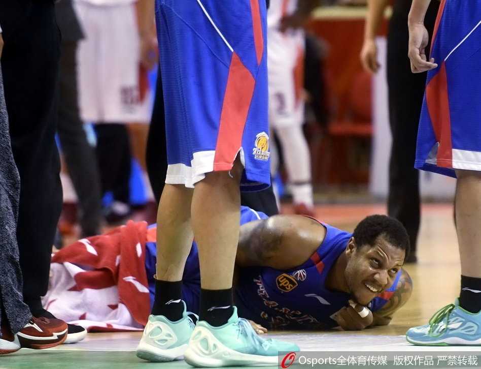 担架上的霍尔曼被推向场外的救护车，闪光灯在他脸上打出斑驳光影，他的眼神空洞而痛苦，双手紧握，仿佛在忍受着巨大的煎熬。