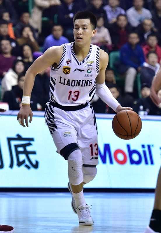 易建联在辽宁男篮内线高高跃起，完成单手劈扣，展现其惊人的身体素质和统治力