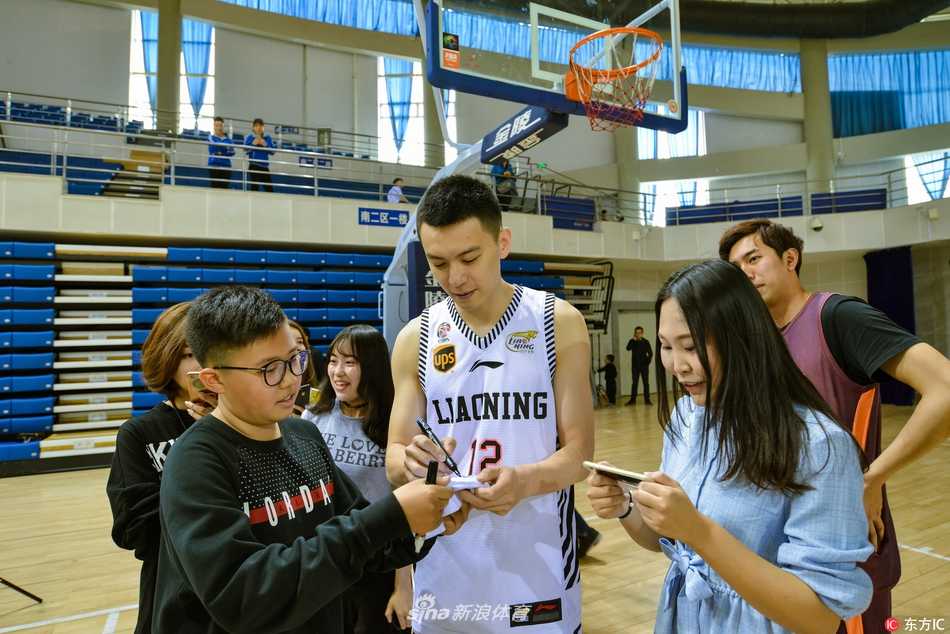 杨鸣身披白色辽宁队战袍，在东北大学体育馆的场地上专注地运球，他坚定的眼神和潇洒的姿态瞬间点燃了现场粉丝的热情。