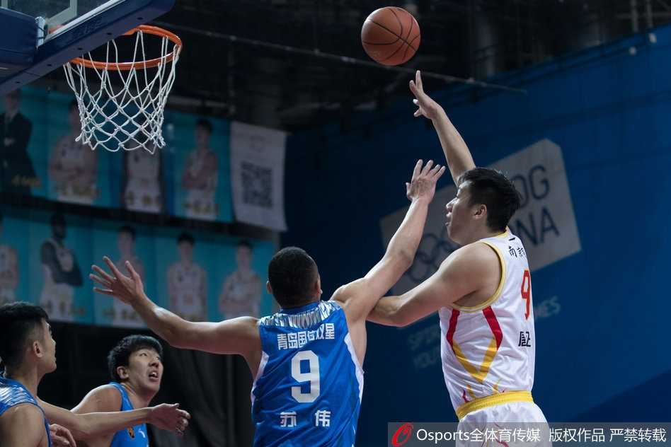 青岛队的内线悍将苏伟在对手的包围中高高跃起，奋力拼抢下前场篮板，他的强硬表现为球队赢得了宝贵的二次进攻机会。