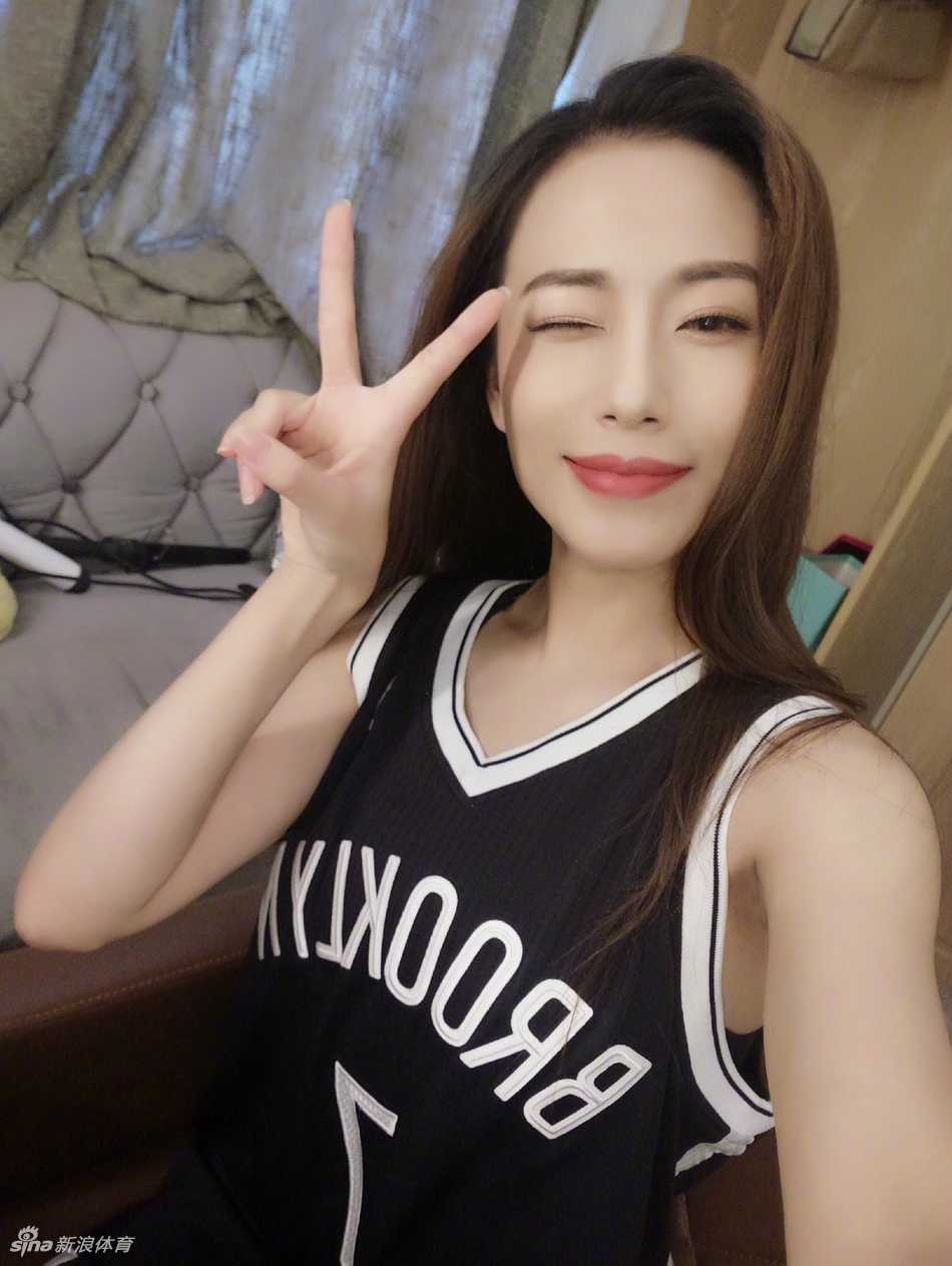 一名扎着丸子头的参赛女孩身穿运动内衣搭配牛仔热裤，健康的肌肉线条在阳光下闪耀，展现出力量与性感的完美平衡