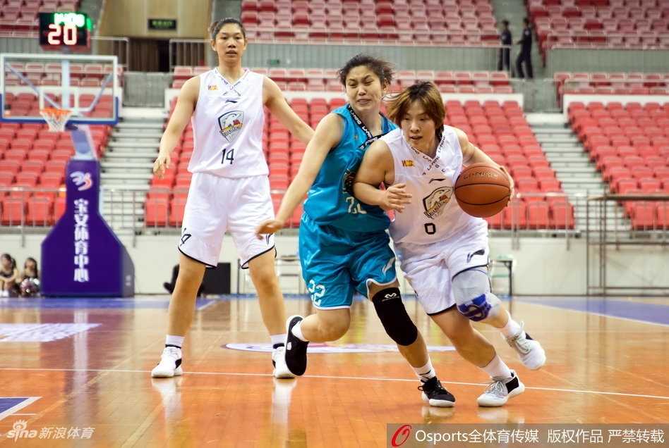 WCBA第八轮焦点战:广东主场不敌大庆,防守大战定乾坤 广东队后卫在三分线外果断出手,皮球在空中划出一道弧线,防守球员奋力扑防,指尖几乎触及篮球。