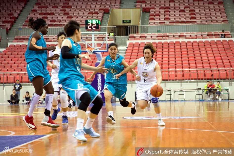 WCBA第八轮焦点战:广东主场不敌大庆,防守大战定乾坤 场边广东队教练组神情专注,主教练双手拢在嘴边,大声向场内球员传达战术指令,眼神充满期待。