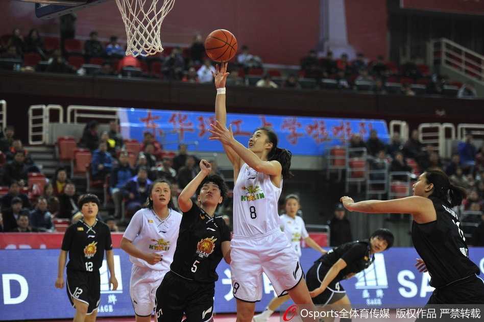 八一女篮队员露雯在对手的严密防守下强行突破，眼神中透露出必胜的决心与坚韧，球场上的汗水清晰可见