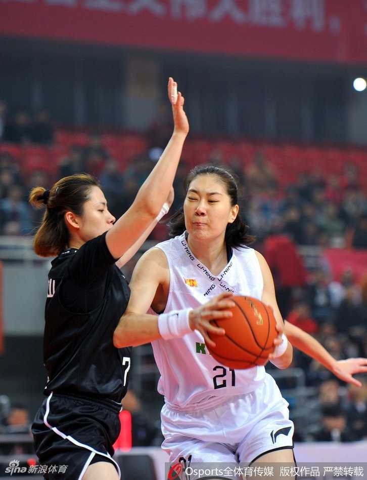 八一女篮核心中锋在江苏队多人包夹之下依然高举高打，眼神坚毅望向篮筐