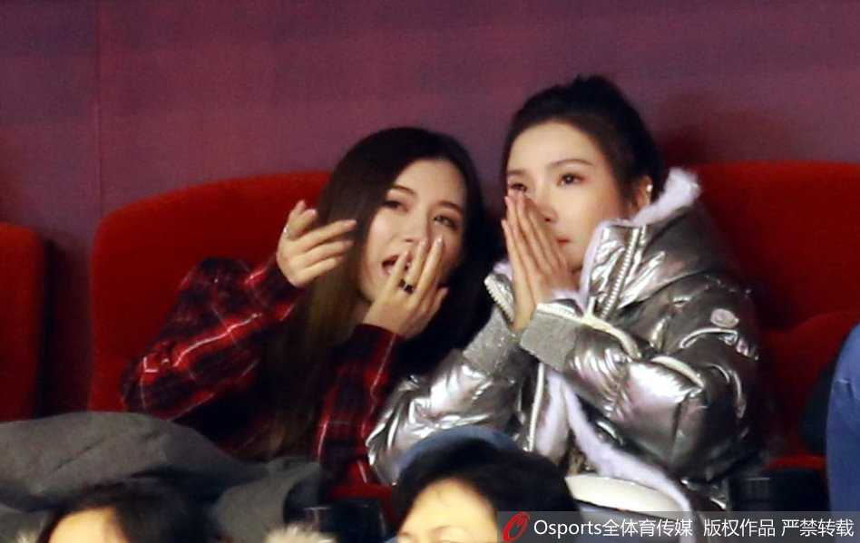 睢冉妻子专注地望着赛场方向，而丁彦雨航女友则手指球场，似乎在兴奋地讨论着刚才小丁那次精彩的快攻得分