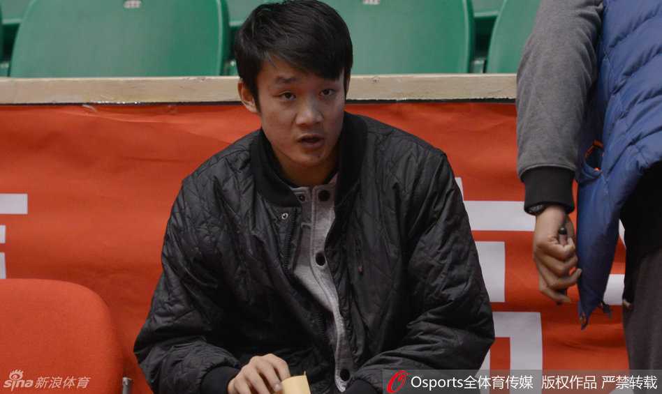 核心丁彦雨航独自坐在场边，双手托腮，眉宇间紧锁，仿佛在思考着当晚比赛的每一个战术细节，神情专注而凝重。