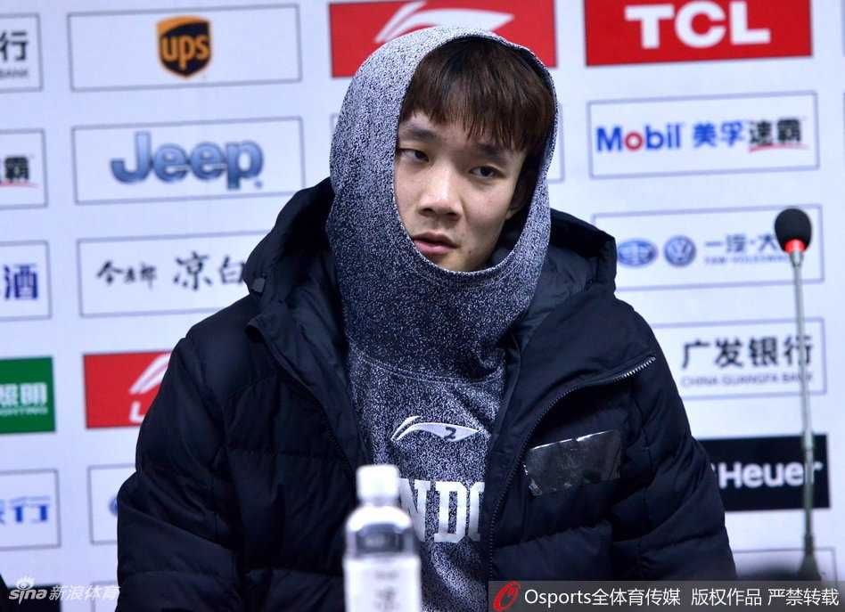 他紧紧抿着嘴唇，整个面部线条紧绷，一副严肃认真、正在努力集中注意力听问题的模样。