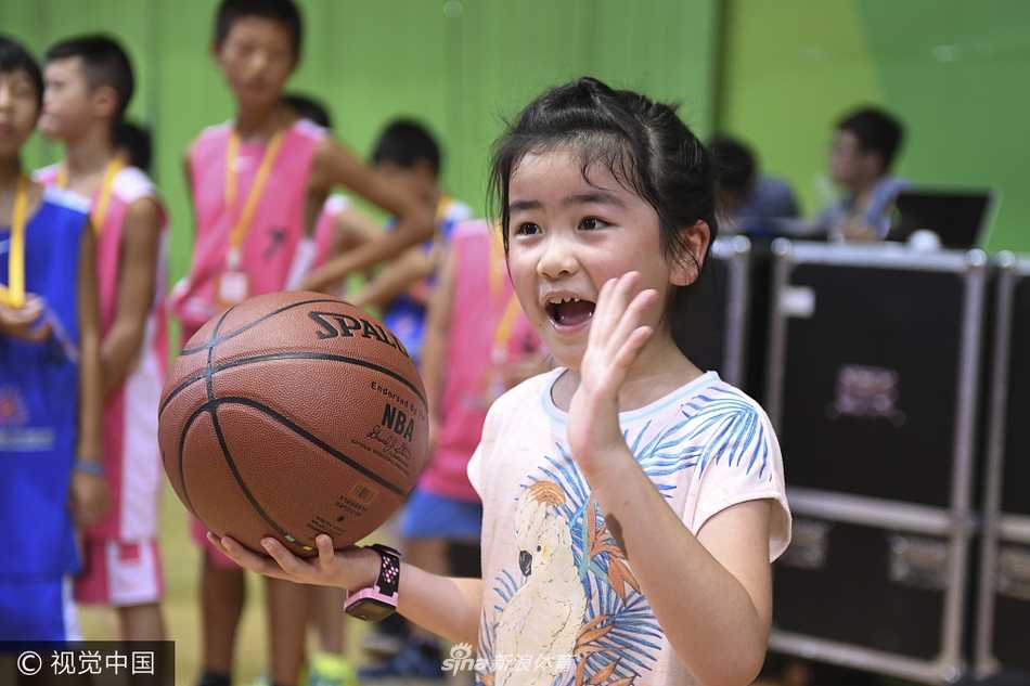 镜头拉近，姚沁蕾在母亲叶莉的陪伴下，即使是在场边休息，也不忘摆弄手中的篮球，这份对篮球的喜爱仿佛是刻在基因里的本能。