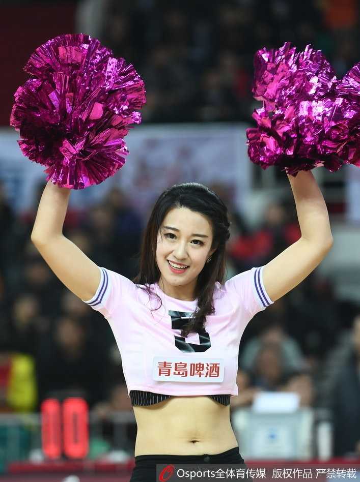 在技术台狭窄的区域里，一位宝贝正完成一个高难度的下腰动作，身体的柔韧性展现得淋漓尽致。她身后的队友们则保持着完美的队形，聚光灯下，她们不仅是助威者，更是此刻舞台中央的绝对主角。