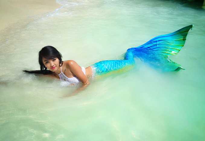 篮球宝贝轻摆金色鱼尾，在聚光灯下宛如刚上岸的塞壬，眼神中透着灵动与娇媚。