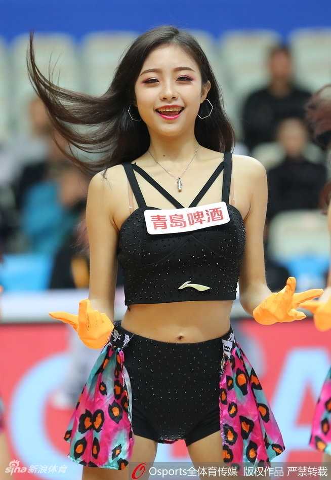 在柔和的光影下，一名拉拉队员单手叉腰侧身站立，紧身的表演服勾勒出优美的身材曲线。她面容精致，嘴角含着一抹浅浅的微笑，甜美中带着一丝羞涩，宛如从画中走出的邻家女孩，让人移不开眼。