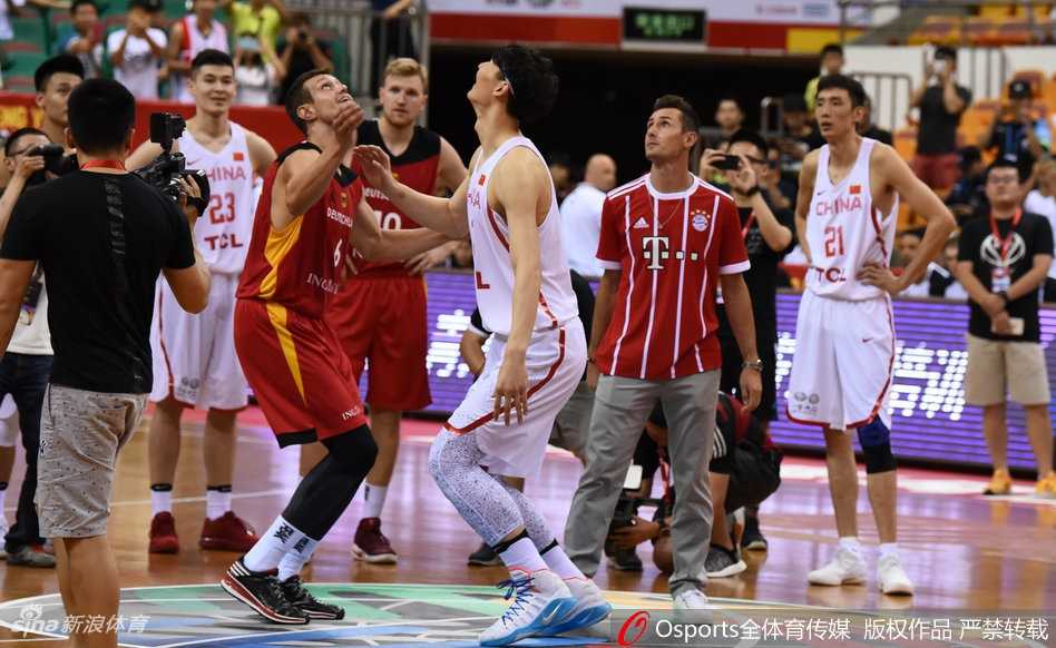 克洛泽面带标志性微笑步入篮球赛场，他身着一袭休闲白衣，向四周热情的观众挥手致意，仿佛将绿茵场的荣耀带到了篮球圣地。