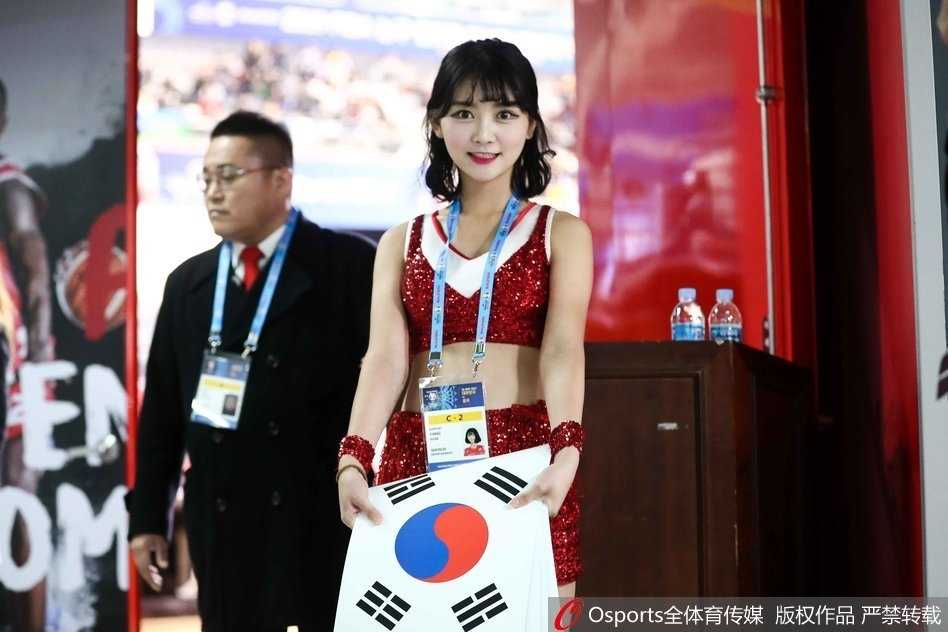 礼仪小姐手持引导牌侧面而立，侧颜线条优美流畅，韩服的独特剪裁勾勒出曼妙身姿